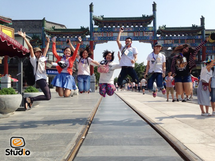 Students jumping in front of a traditional Chinese gate